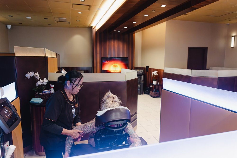 A therapist beginning a treatment in a Spa Here privacy suite at DFW