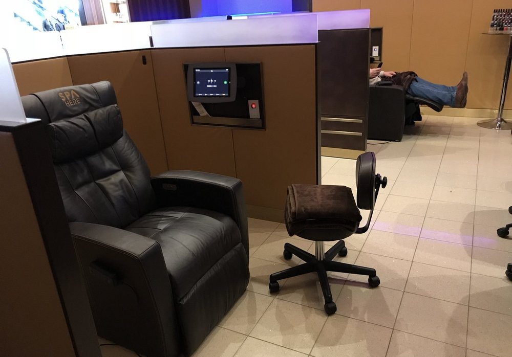 A Spa Here recliner with its own console, set apart from the concourse